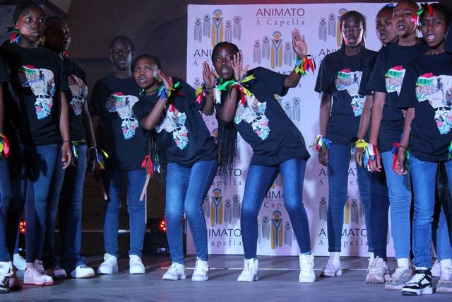 Learners performing on stage in matching black T-shirts